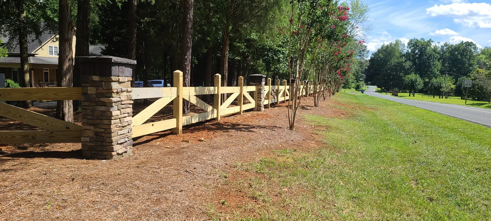 Wood rail between stacked-stone columns